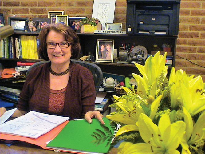 Happy birthday: Kathy Hubbard sits at her desk in her bookkeeping-service office, with yellow birthday flowers from her partner, Annise Parker.
